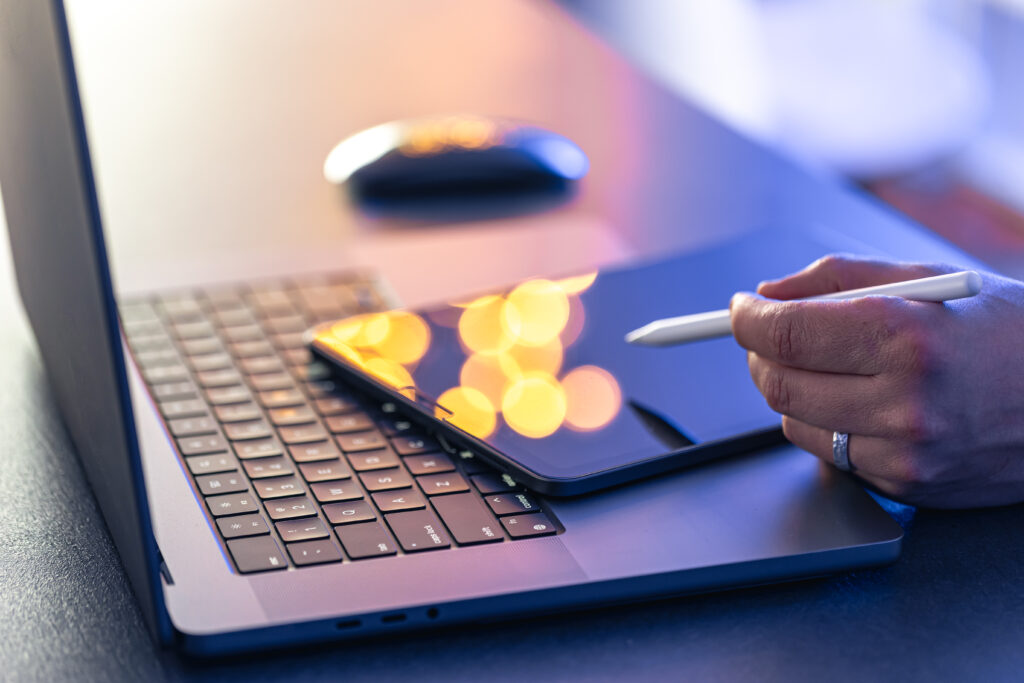 Profissional da reforma tributária trabalhando com um computador e um tablet.