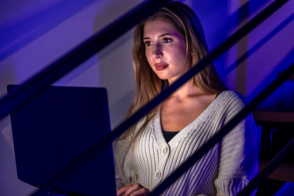 Uma mulher trabalhando com um notebook representa os profissionais de cibersegurança.