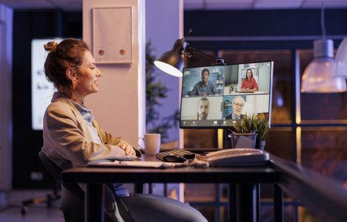 Manager explaining marketing statistics during online videocall meeting conference, working late at night at company profit report with remote team in startup office. Corporate concept