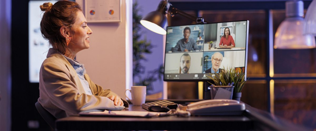 Manager explaining marketing statistics during online videocall meeting conference, working late at night at company profit report with remote team in startup office. Corporate concept