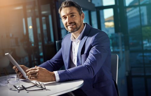 Portrait, tablet and research with a business man on a mission in his office at work for success. Corporate, internet and search with a male employee, manager or boss working on his company vision.
