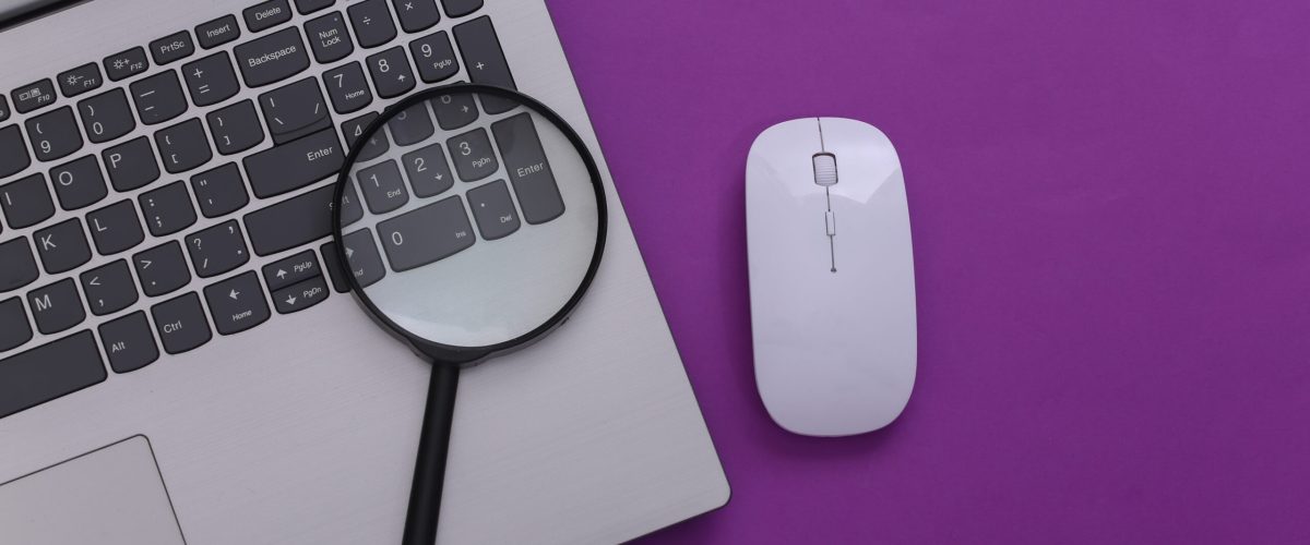 Search information. Laptop with pc mouse, magnifier on purple background. Top view