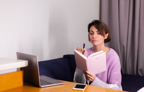 Woman at home with notepad notebook thinking about plans