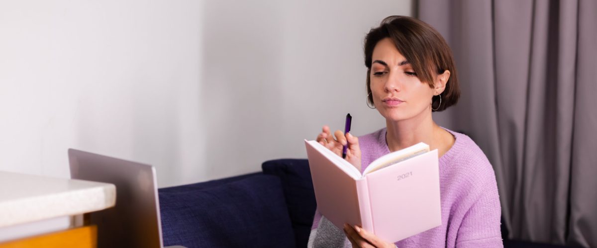 Woman at home with notepad notebook thinking about plans